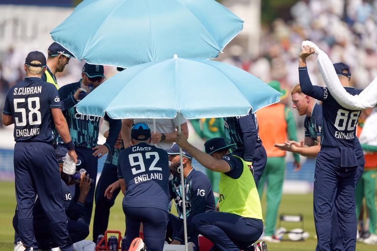 England players shelter under umbrellas as they take a drinks break and use ice to cool down
