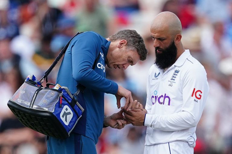 The England physio tends to Moeen Ali's injured index finger